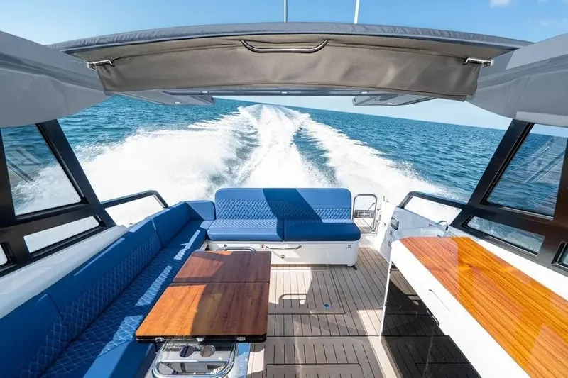 Slide: The Image of 2023 Bavaria Vida 33 yacht interior with blue seating, wooden tables, and ocean view. - 3