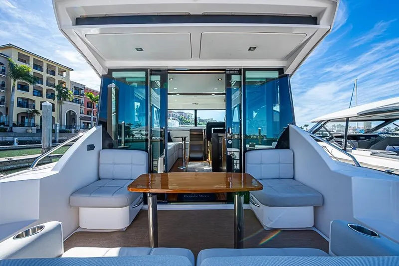 Slide: The Image of 2017 Tiara Yacht Coupe with luxurious seating and table, docked at a marina. - 12