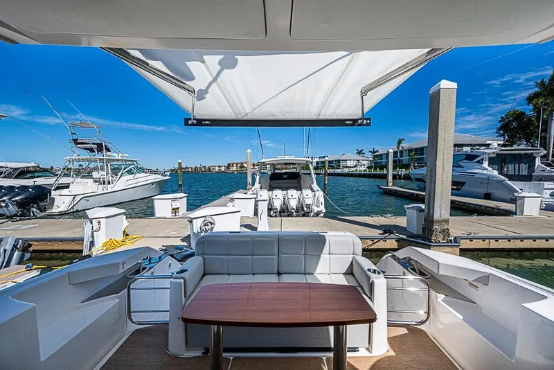 Slide: The Image of 2017 Tiara Yacht Coupe docked at marina with seating and canopy. - 14