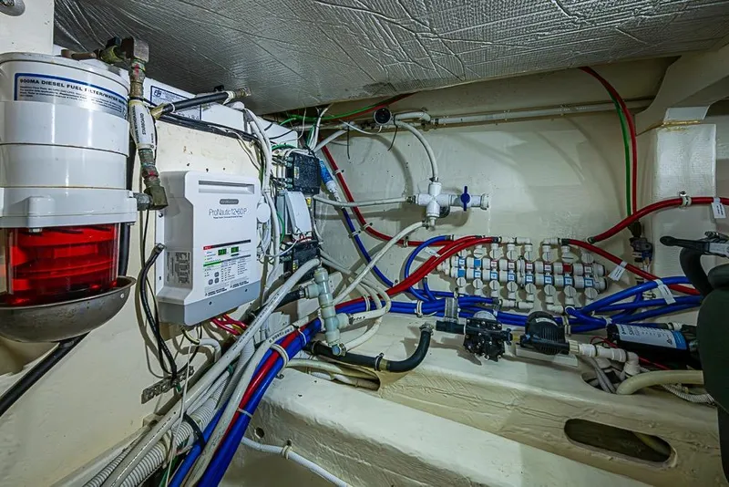 Slide: The Image of Engine room of a 2017 Tiara Yacht Coupe with complex wiring and equipment. - 19