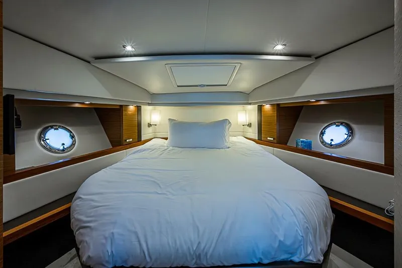 Slide: The Image of Luxurious 2017 Tiara Yacht coupe bedroom with elegant bedding and porthole windows. - 21