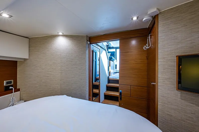 Slide: The Image of Interior of 2017 Tiara Yacht coupe, featuring a cozy bedroom with modern wood finishes. - 23