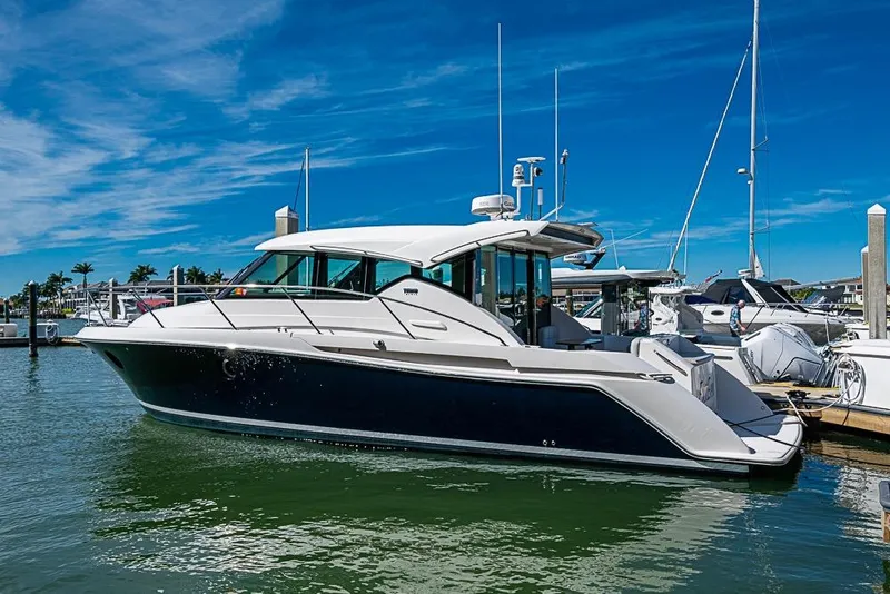 Slide: The Image of 2017 Tiara Yacht Coupe docked in a marina under a clear blue sky. - 3