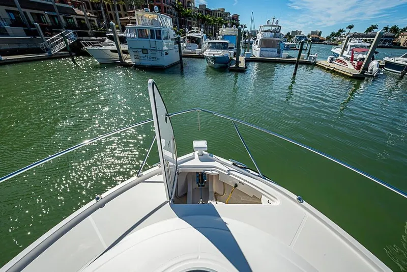 Slide: The Image of 2017 Tiara Yacht Coupe docked in a sunny marina with sparkling water. - 7