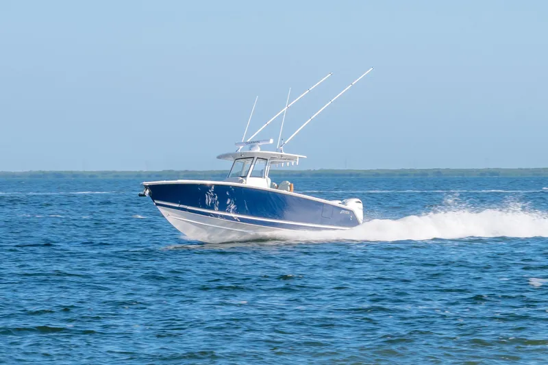 The Image of 2026 Jupiter 340LS boat cruising on open water, clear blue sky background. - 0