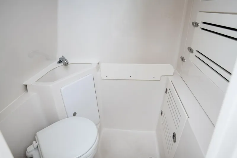 Slide: The Image of Manufacturer Provided Image: Compact white bathroom in 2026 Jupiter 38 boat, featuring toilet and storage cabinets. - 10