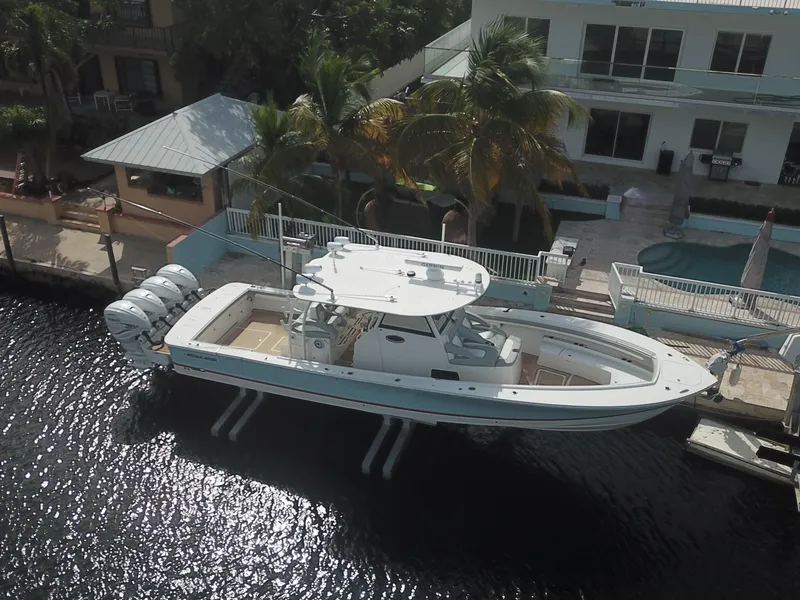 Slide: The Image of 2022 Regulator 41 boat docked by waterfront home with palm trees. - 11