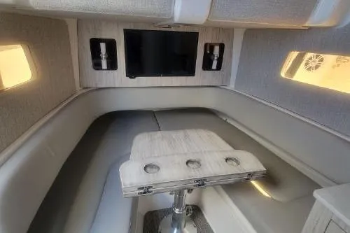 Slide: The Image of 2022 Regulator 41 boat interior with seating, table, and mounted TV. - 39