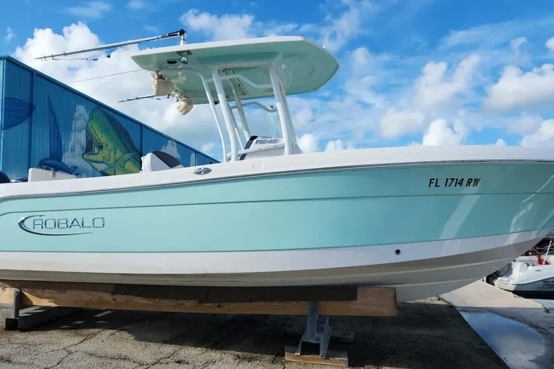 The Image of 2019 Robalo R242 Center Console boat on display, light blue hull, sunny day. - 0