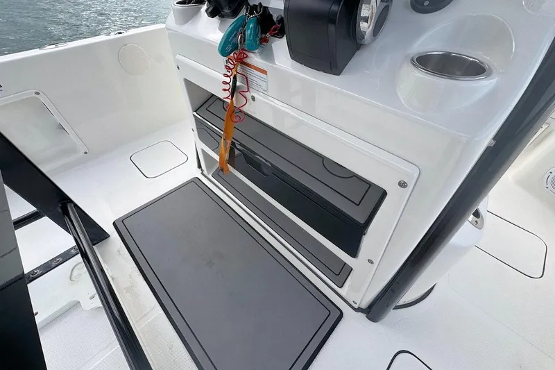 Slide: The Image of 2021 World Cat 235 CC boat interior with storage compartments and control panel. - 12