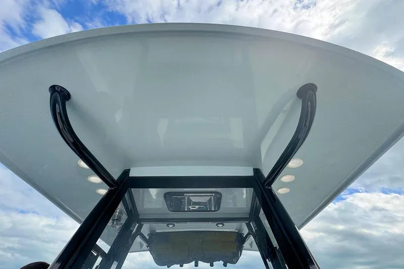 Slide: The Image of 2021 World Cat 235 CC boat's T-top against a cloudy sky background. - 17