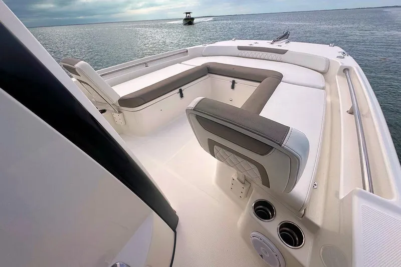 Slide: The Image of 2021 World Cat 235 CC boat interior with cushioned seating on calm water. - 19