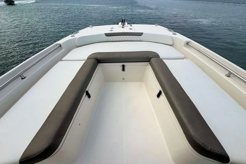 Slide: The Image of 2021 World Cat 235 CC boat interior with cushioned seating, on calm water. - 20