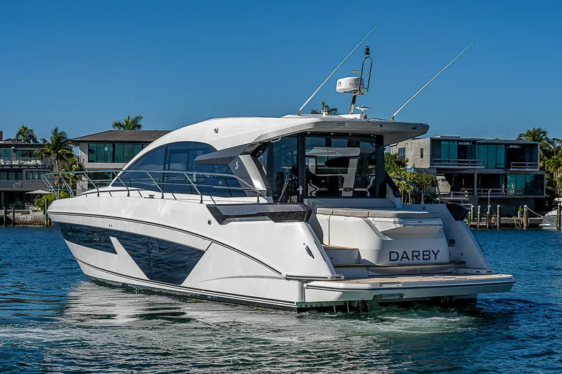 Slide: The Image of Beneteau Gran Turismo 45 yacht, 2022, on calm water near modern homes. - 12