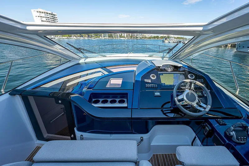 Slide: The Image of 2022 Beneteau Gran Turismo 45 yacht helm station with waterfront view. - 45