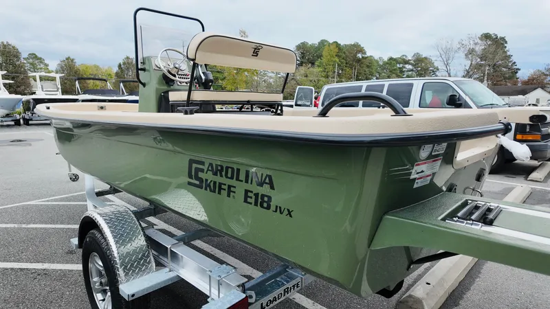 Slide: The Image of 2025 Carolina Skiff E18 JVX CC Swamp Edition boat on trailer in parking lot. - 4