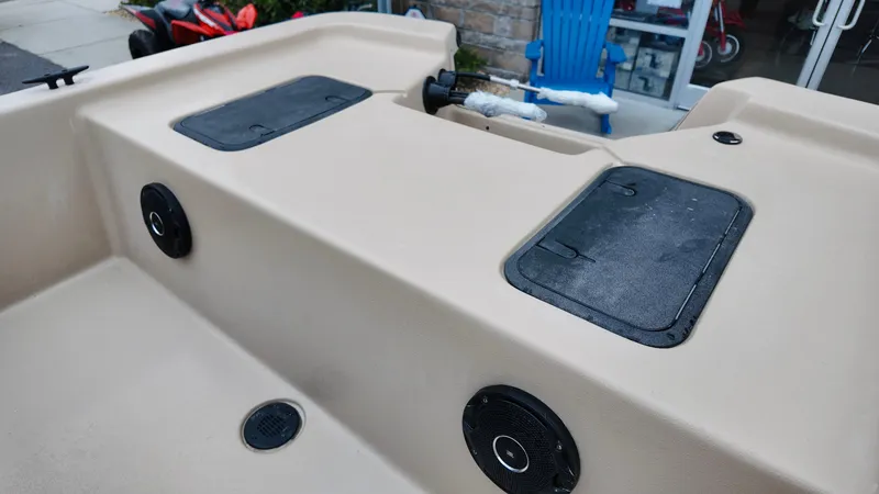 Slide: The Image of 2025 Carolina Skiff E18 JVX CC Swamp Edition boat interior with storage compartments and speakers. - 7