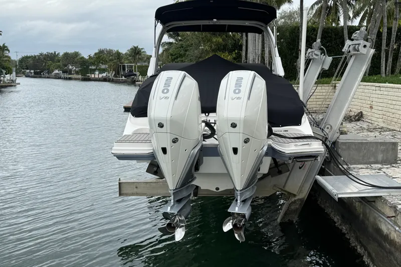 Slide: The Image of 2025 Sea Ray SDX 290 Outboard boat docked by a scenic canal with palm trees. - 17