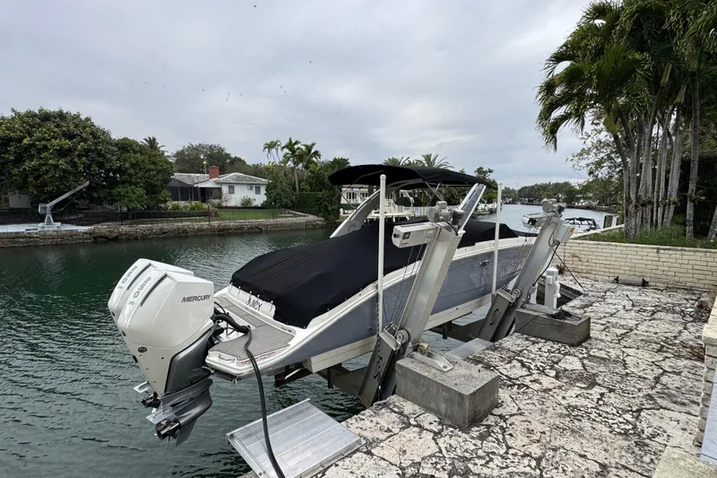 Slide: The Image of 2025 Sea Ray SDX 290 Outboard boat docked by a scenic waterfront. - 2