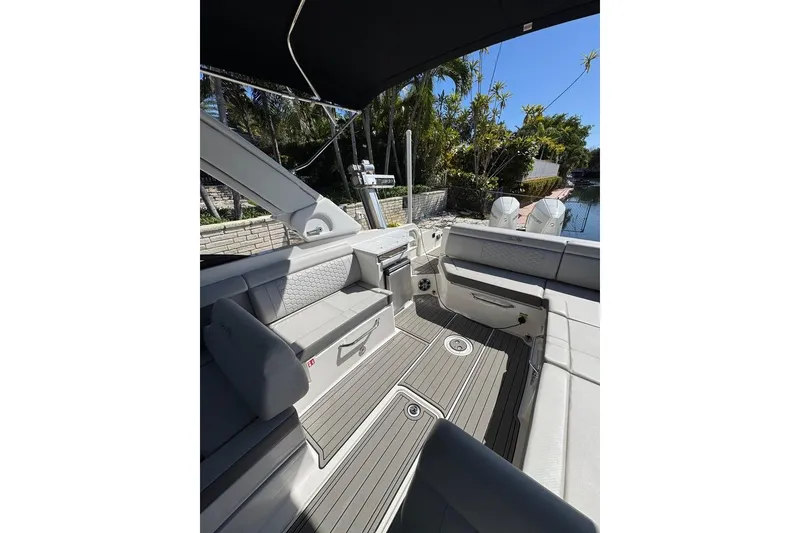 Slide: The Image of 2025 Sea Ray SDX 290 Outboard interior with seating and deck, under a canopy. - 25