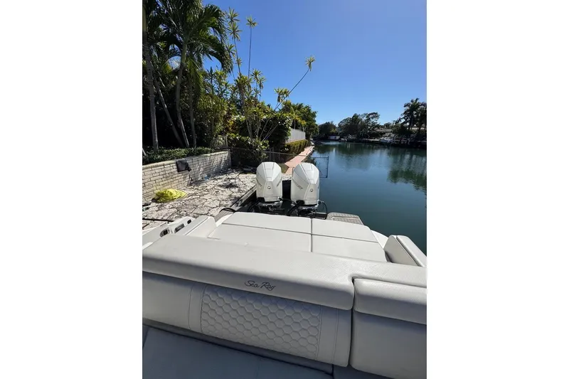 Slide: The Image of 2025 Sea Ray SDX 290 Outboard docked by a serene canal with lush greenery. - 29