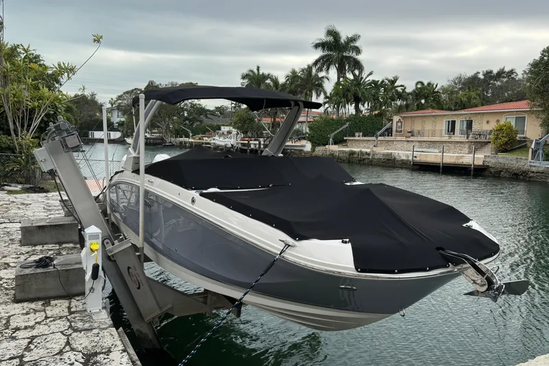 Slide: The Image of 2025 Sea Ray SDX 290 Outboard boat on lift by waterfront, covered and docked. - 3