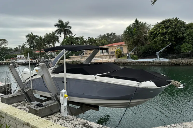 Slide: The Image of 2025 Sea Ray SDX 290 Outboard boat docked by a canal with lush surroundings. - 4