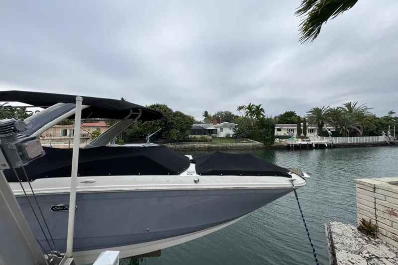 Slide: The Image of 2025 Sea Ray SDX 290 Outboard boat docked by a scenic waterfront. - 5