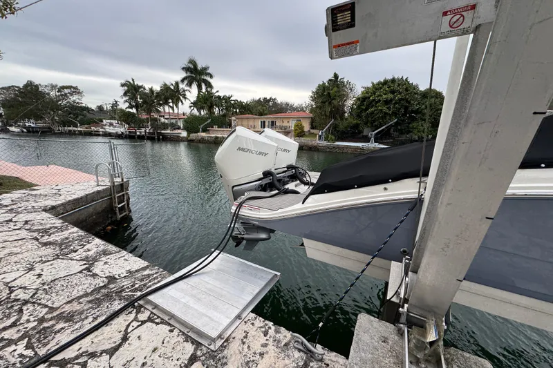 Slide: The Image of 2025 Sea Ray SDX 290 Outboard boat docked by waterfront homes. - 6