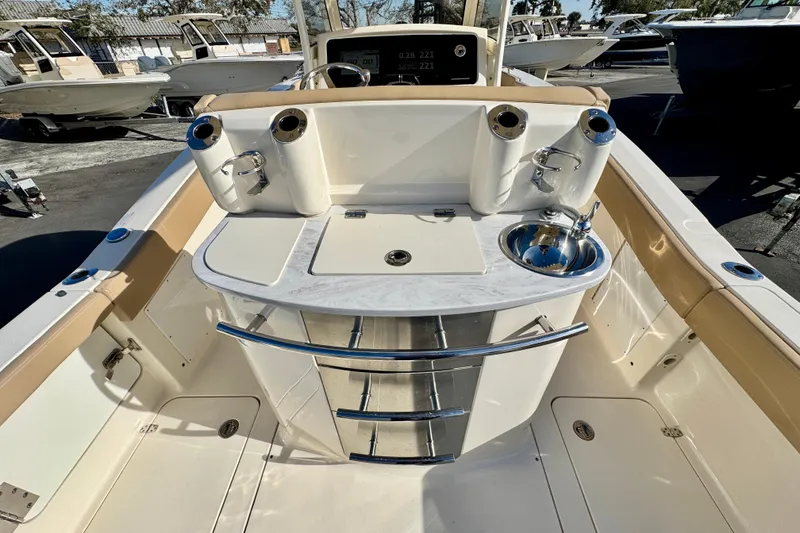 Slide: The Image of 2021 Scout 277 LXF boat interior with fishing rod holders and sink. - 10