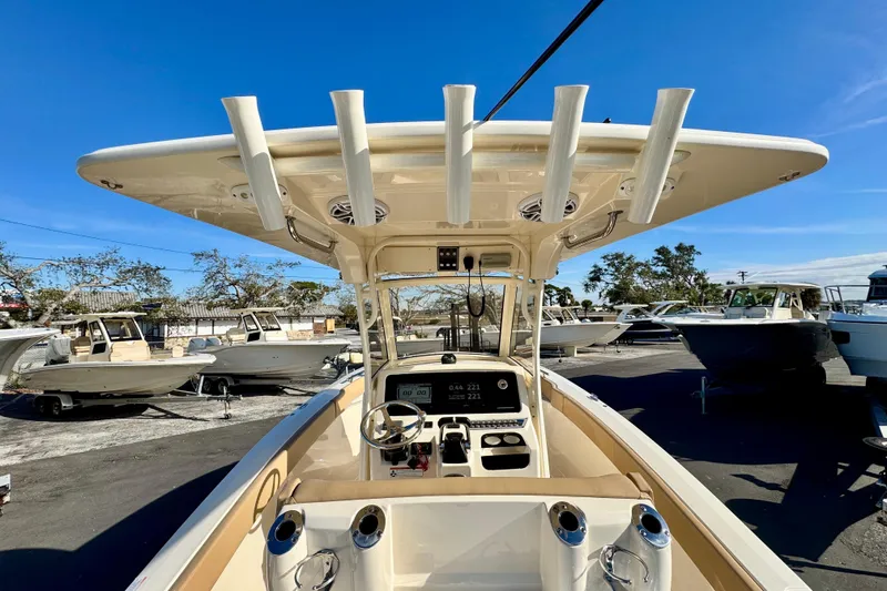 Slide: The Image of 2021 Scout 277 LXF boat interior with helm, rod holders, and dashboard display. - 15