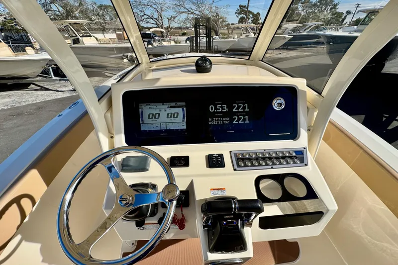 Slide: The Image of 2021 Scout 277 LXF boat dashboard with steering wheel and navigation display. - 17