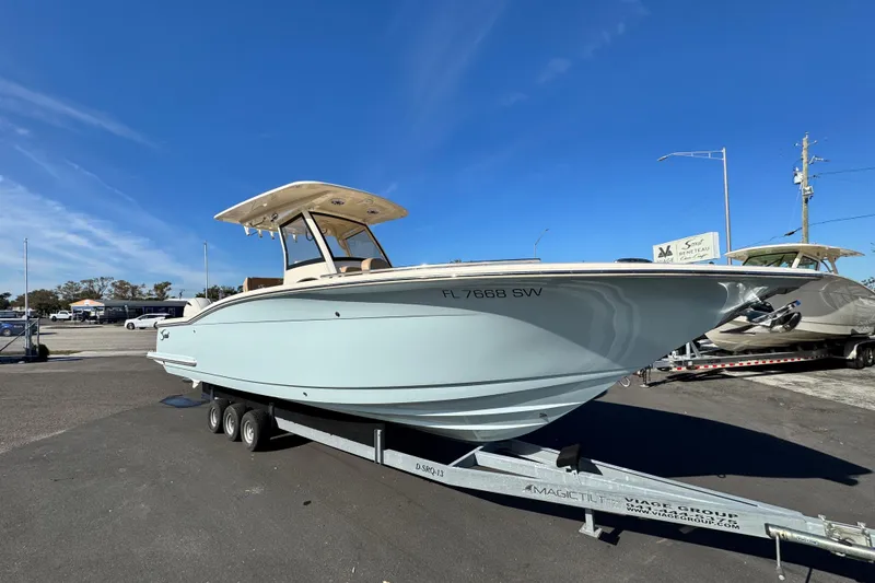 Slide: The Image of 2021 Scout 277 LXF boat on trailer under clear blue sky. - 2
