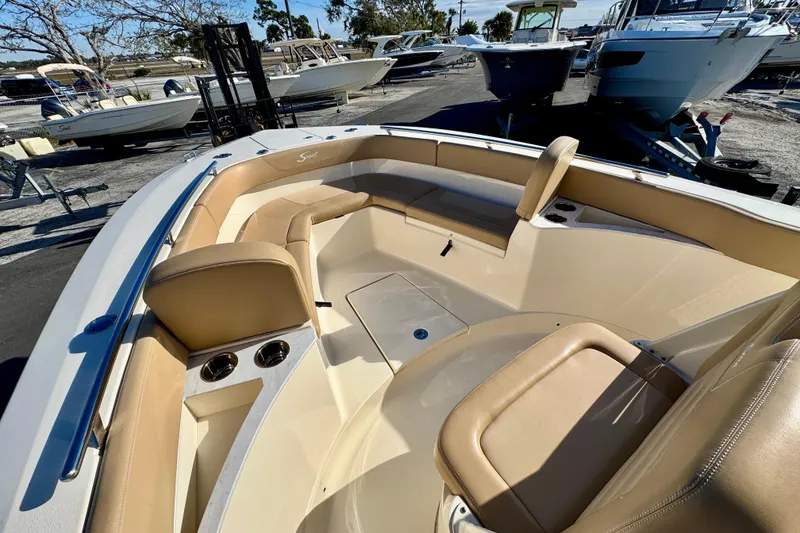 Slide: The Image of 2021 Scout 277 LXF boat interior with tan seating and cup holders. - 21