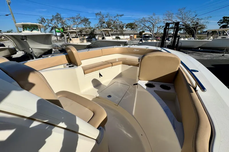 Slide: The Image of 2021 Scout 277 LXF boat interior with tan seating and cup holders. - 22
