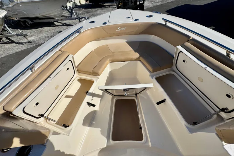 Slide: The Image of 2021 Scout 277 LXF boat interior with tan seating and storage compartments. - 23
