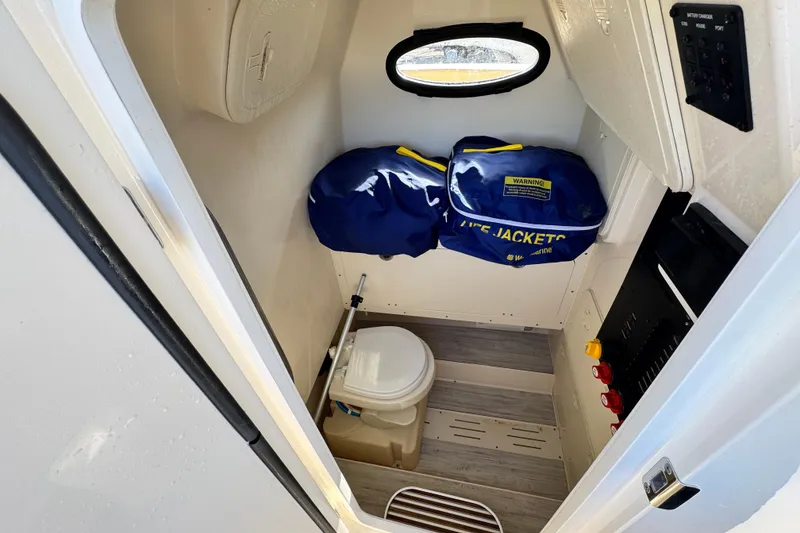 Slide: The Image of 2021 Scout 277 LXF boat interior with life jackets and compact toilet. - 27