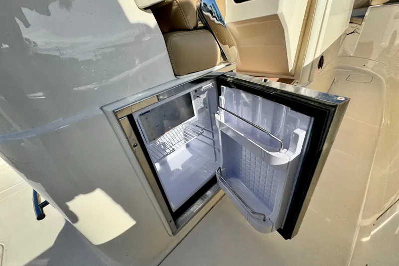 Slide: The Image of 2021 Scout 277 LXF boat with open onboard refrigerator, showcasing interior storage. - 29