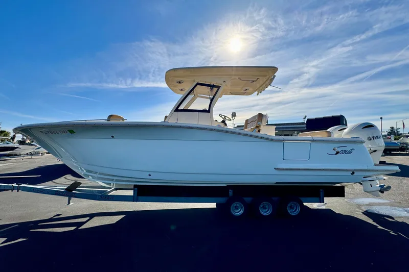 Slide: The Image of 2021 Scout 277 LXF boat on trailer under sunny sky. - 3