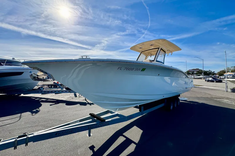 Slide: The Image of 2021 Scout 277 LXF boat on trailer under clear blue sky. - 5