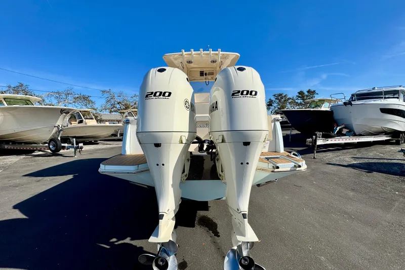 Slide: The Image of 2021 Scout 277 LXF boat with dual Yamaha 200 engines, parked outdoors. - 6
