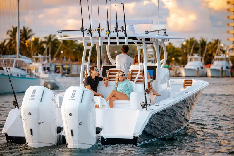 Slide: The Image of Manufacturer Provided Image: 2026 Jupiter 40 boat with people relaxing, featuring dual engines and fishing rods, on a sunny day. - 4