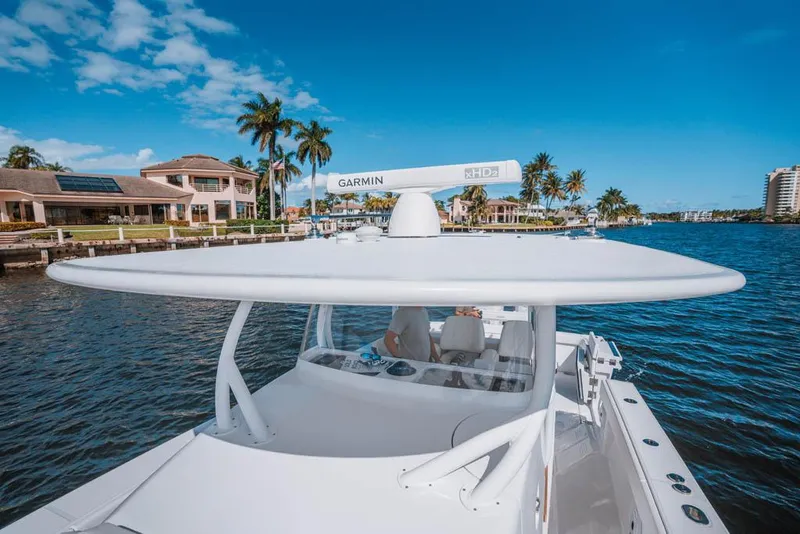 Slide: The Image of Manufacturer Provided Image: 2026 Jupiter 40 boat on water, featuring Garmin radar, with waterfront homes and palm trees in background. - 5