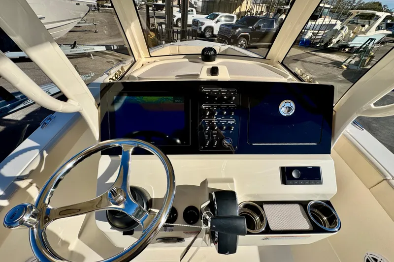 Slide: The Image of 2026 Scout 240 XSF boat dashboard with steering wheel and navigation controls. - 13