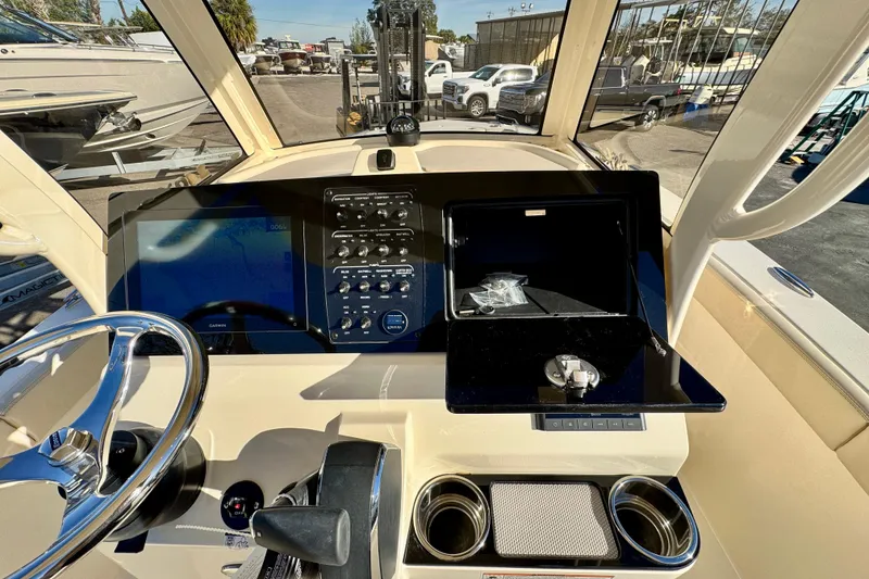 Slide: The Image of 2026 Scout 240 XSF boat dashboard with steering wheel, controls, and navigation display. - 14