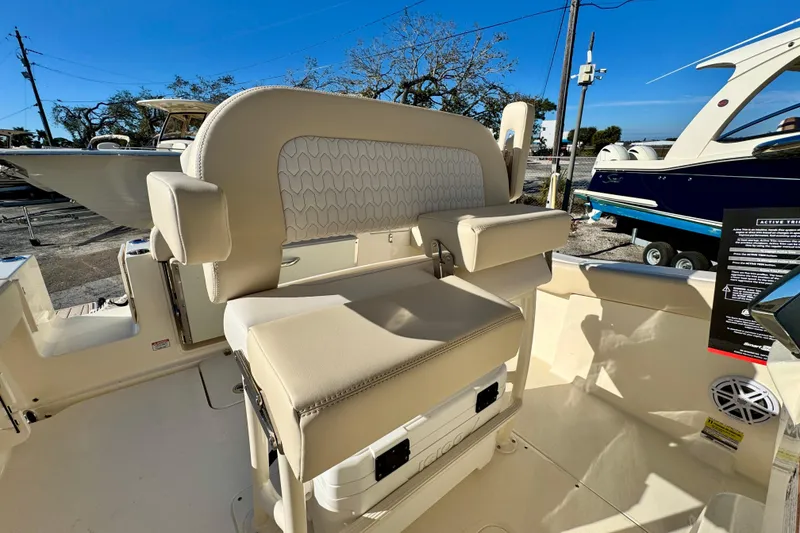 Slide: The Image of 2026 Scout 240 XSF boat interior with beige seating and armrests. - 15