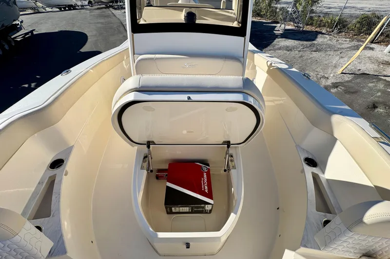 Slide: The Image of 2026 Scout 240 XSF boat interior with open storage compartment and Mercury box. - 23
