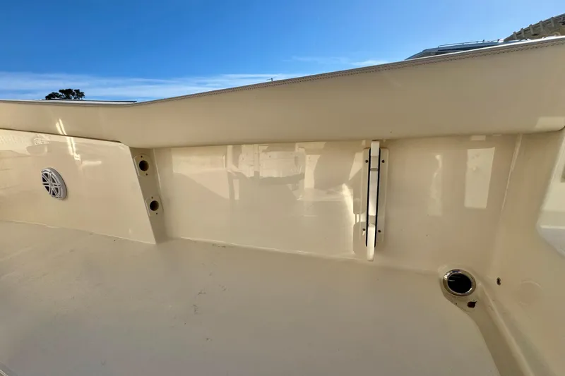 Slide: The Image of 2026 Scout 240 XSF boat interior with speaker and rod holders, under clear blue sky. - 29