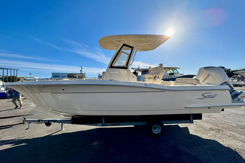 Slide: The Image of 2026 Scout 240 XSF boat on trailer under clear blue sky. - 3