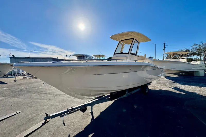 Slide: The Image of 2026 Scout 240 XSF boat on trailer under clear blue sky. - 4